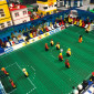 Minifiguren spielen im Stadion Fu&szlig;ball.
