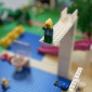 Man sieht eine Minifigur oben auf dem Sprungbrett im Freibad, die noch nicht genau wei&szlig;, ob sie springen soll, weil es sehr  hoch ist. 